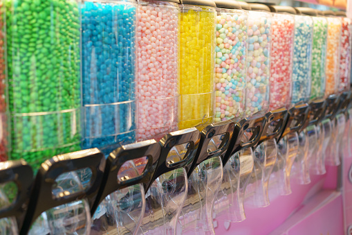 A vibrant display of candy dispensers filled with a variety of colorful sweets, offering a delightful choice for those with a sweet tooth