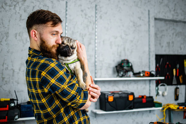 Repairman holds Pug in his workshop