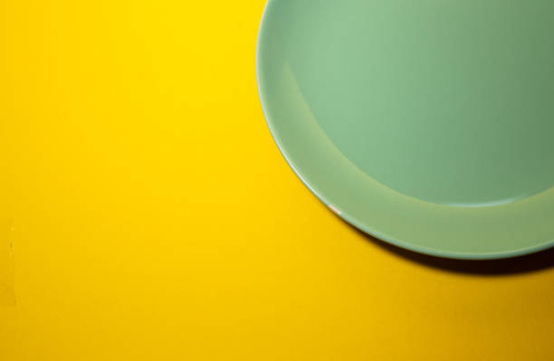 assiette verte sur fond jaune. vue de dessus - passover seder seder plate table photos et images de collection