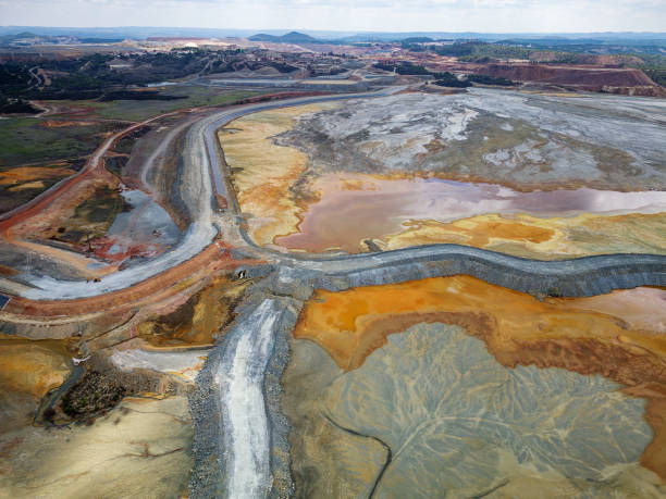 Aerial drone view of Mining activity in Minas de Riotinto in Spain. Apocalypse scenery. Mining village in Andalusia. Earth destruction. Disruption of nature. Extracting natural resources from the Earth to sell on the world market. Ecological disaster. Climate change. Water and river pollution. vista aérea con dron de la actividad minera en minas de riotinto en españa. escenario apocalíptico. destrucción de la tierra. alteración de la naturaleza. extraer recursos naturales de la tierra para venderlos en el mercado mundial. desastre ecológic