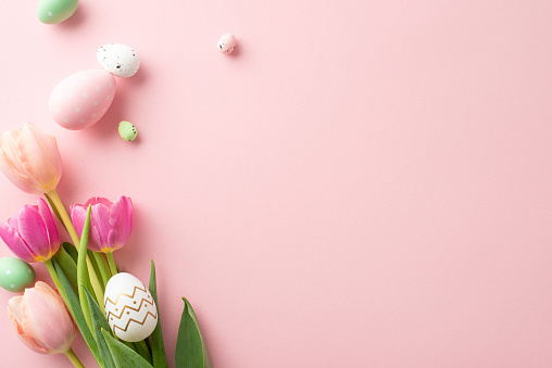 Easter charm in every detail â a high-angle top view of lively eggs, and fresh tulips set against a light pink background, providing space for messages