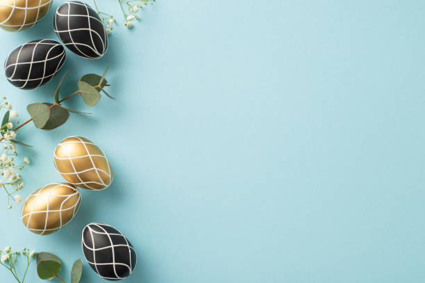 istock Easter celebration concept: Top view of rich black and gold eggs, natural eucalyptus foliage, gypsophila, meticulously placed on soft blue background, offering blank space for messages or marketing 2015274562