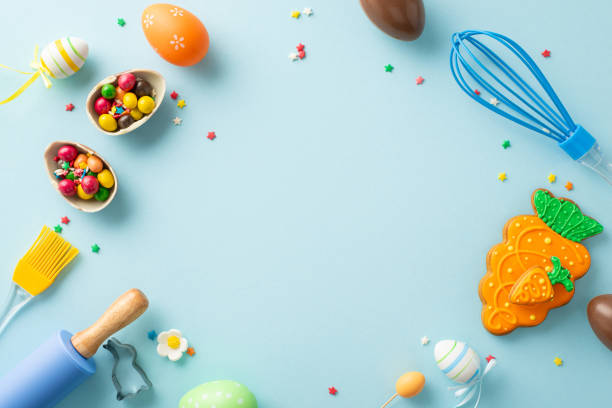 istock Easter delight at confectionery store. Top view of table with baking tools. Adorable pastry, cookie cutter, chocolate eggs, candies, sprinkles on light blue background. Text-friendly space available 2015275088