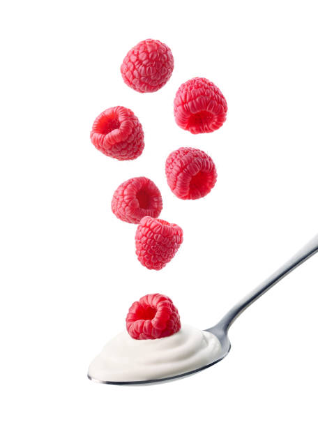 istock Spoon of fresh greek yogurt and falling raspberries on white background 2015276173