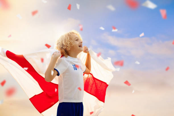 England football supporter on stadium. English fans on soccer pitch watching team play. Group of British supporters with flag and national jersey cheering for UK. Championship game. Go Britain!