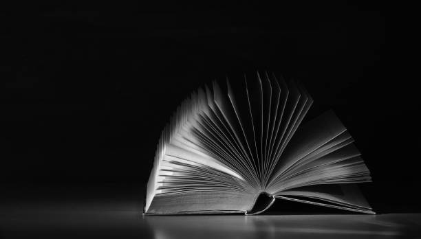 istock Open book close up, black and white, reading, education, knowledge concept.Black background,free copy space. 2015280591