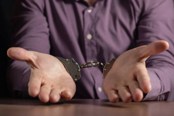 istock stressed out businessman hands bothered with handcuffs suffering at custody for concept of suspicious business 2015283273