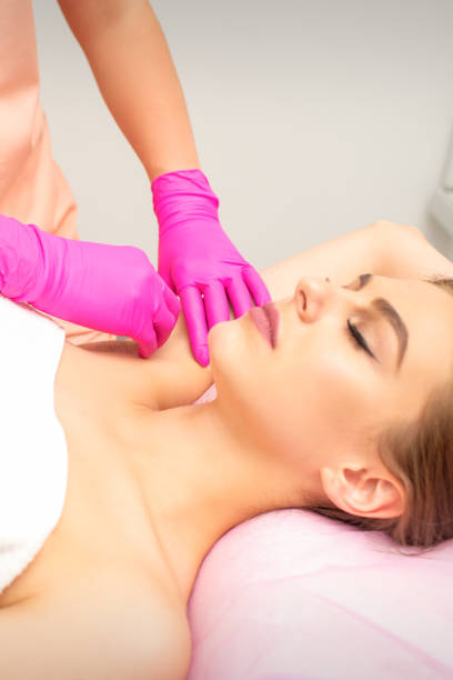 waxing. depilation under the armpits of the young woman lying with closed eyes in the spa salon. - deodorant women hygiene body care photos et images de collection