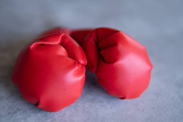 istock A close-up image of red boxing gloves resting on a gray canvas surface. 2015298655