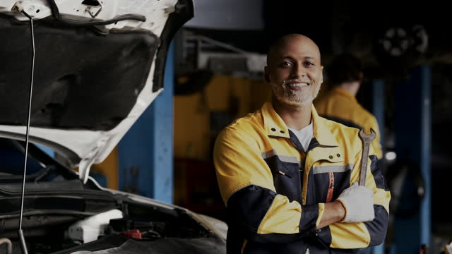 Portrait of male mechanic working on a vehicle in a car service.
