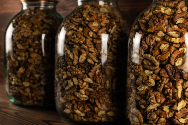 Shelled walnuts inside jar glass close up.
