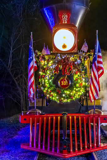 Elizabethtown, Pennsylvania, December 6, 2022 - A Close View of an Antique 1860's Steam Engine Steamed Up, all Decorated for Christmas, on a Clear Night