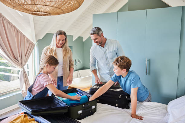istock Smiling family packing clothes into suitcases for a vacation 2015344971