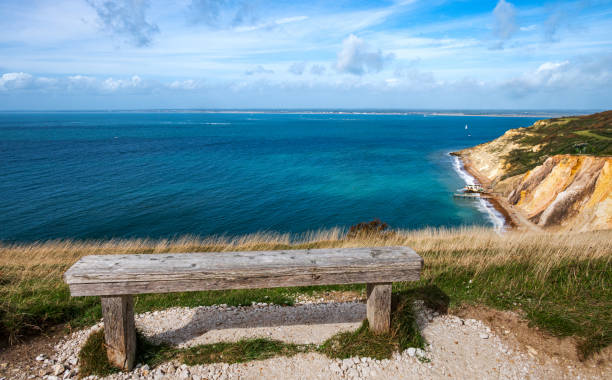 istock Ocean view with a wooden bench on the cliff 2015349894