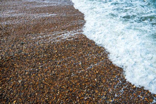 Splashes from tidal waves washing the small pebbles on a shingle beach on Isle Of Wight