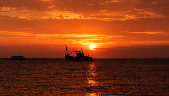 Sunset with fishing vessel silhouette at Goa