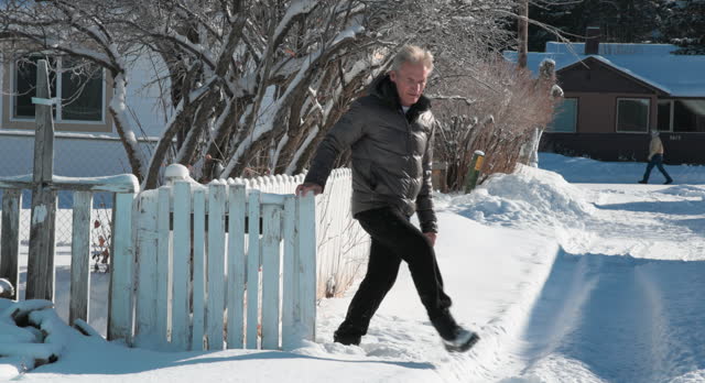 Mature man walks through snowy winter landscape