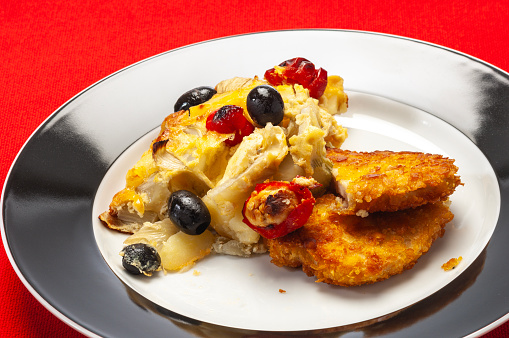 Food and drink: plate of Crispy Baked Chicken Cordon Bleu and fennel, tomato and olives.