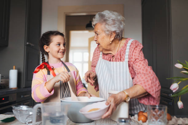 istock Grandmother with grandaughter preparing traditional easter meals, baking cakes and sweets. Passing down family recipes, custom and stories. 2015381927
