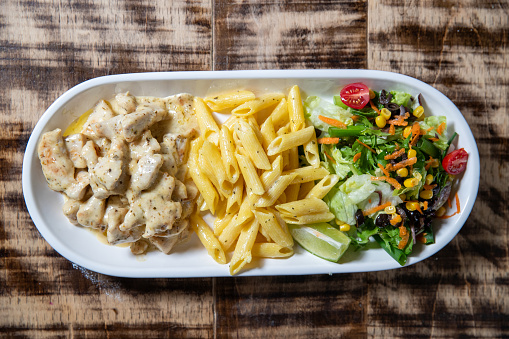 Overhead image of Chicken in Curry Sauce, Pasta and Salad