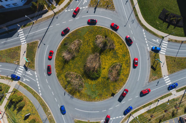 Wide angle aerial drone view of a traffic roundabout red and blue cars. Composite image.