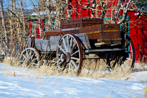 Old Wooden Wagon, Como, Colorado (USA) Como, Colorado, USA - February 12, 2024: An old wooden wagon sits in the yard of a home in the historic town of Como, a former coal mining and railway center during the late 1800s. covered wagon horse cart snow winter stock pictures, royalty-free photos & images