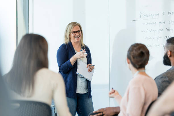 istock Mature female supervisor stands at the whiteboard to present 2015414655