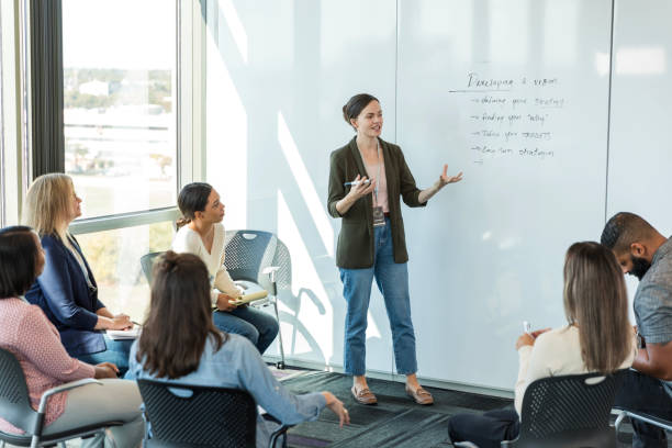 istock Mid adult female supervisor gestures while talking to her team 2015415003