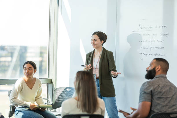 istock Mid adult female supervisor smiles while asking the team feedback questions 2015415004