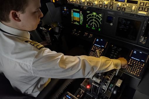 Captain firmly grips engine control lever during flight. Pilot ready to assert control over aircraft propulsion in event of emergency