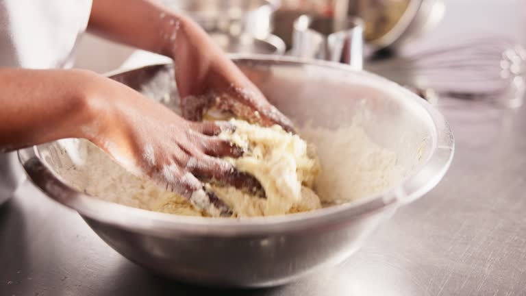 Hands, bowl or kneading of sticky dough on table, chef or process of wheat flour on kitchen counter. Baker, working or mixing wet in dry ingredients for cake, hospitality or culinary cooking in hotel