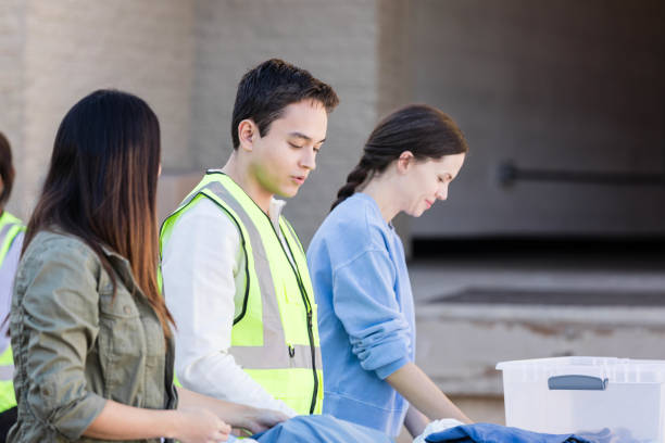 istock Diverse people volunteer to sort donated clothes outside warehouse 2015438593