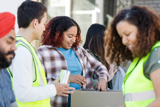 istock Multiracial group works diligently sorting cans and clothes for event 2015438608