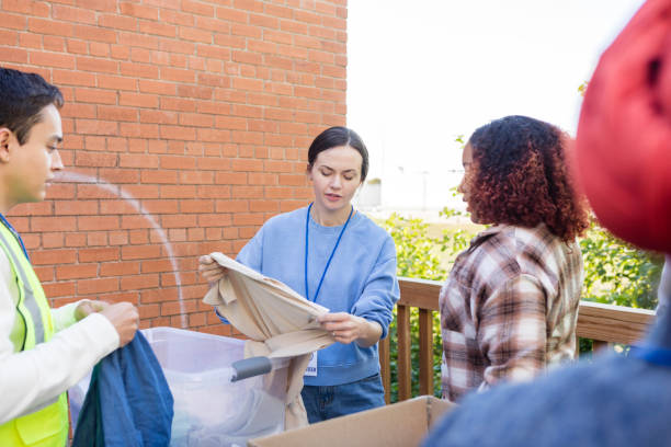 istock Female volunteer coordinator explains how to sort donated clothing 2015438622