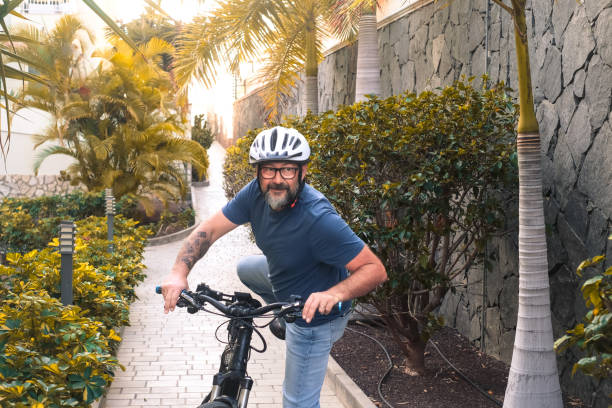 istock Smiling middled aged cyclist man wearing helmet using electric bicycle in weekend activity, healthy sporty lifestyle concept 2015440754