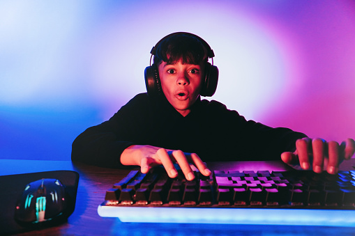Teenager playing strategy video game online inside gaming room. E-sport, technolgy concept