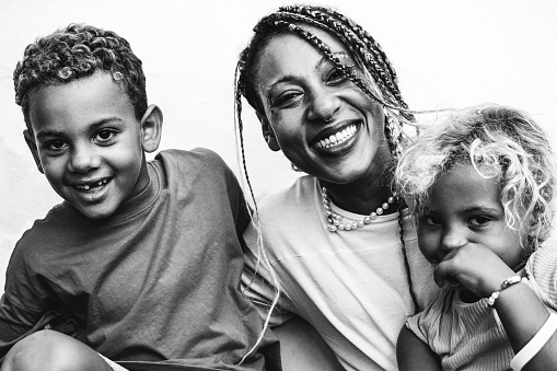 African family having fun outdoors. Mother, daughter and son laughing. Family relationship, Black and white editing