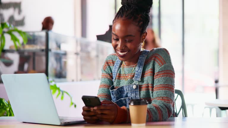 Laptop, phone and black woman freelancer in coffee shop on social media or the internet. Research, technology and African female with cappuccino networking on cellphone and on computer in cafe.