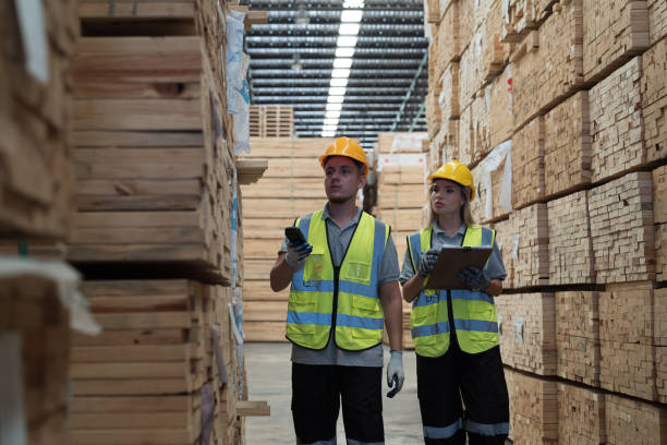 istock Male and female warehouse worker working in lumber storage warehouse. Workers working in timber storage warehouse. Manufacturing and warehouse concept 2015472023