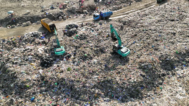 Landfill with garbage trucks unloading junk