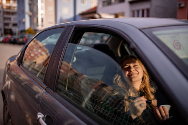 istock Young blonde woman fixing  her makeup in a car 2015484771