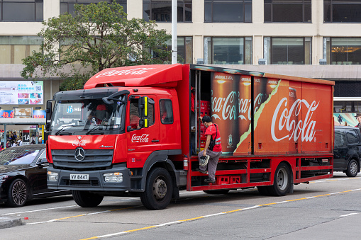 Hong Kong - February 16, 2024 : Deliveryman and Coca-Cola delivery truck in Tsim Sha Tsui, Kowloon, Hong Kong.