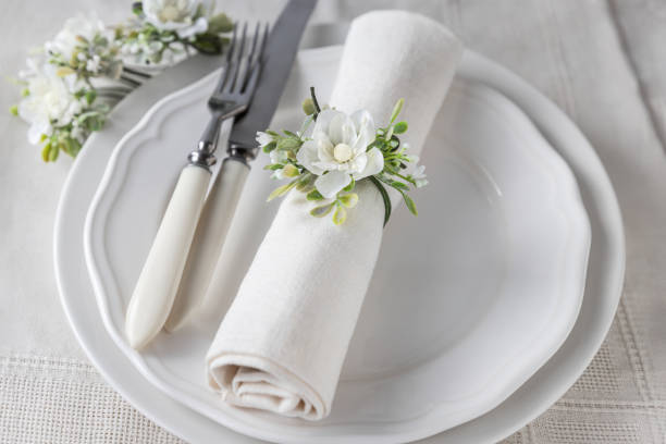 White flower napkin decoration and cutlery on plates angle view