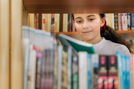 Middle school student choosing a book from the school library