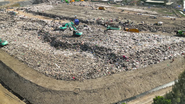 Landfill with garbage trucks unloading junk