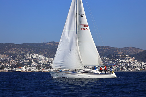 Bodrum, Türkiye. February 03, 2024: Sailboats sail in the blue waters of the Aegean Sea in windy weather on the coast of the famous holiday resort of Bodrum. Boat owners have a pleasant weekend with their sails in the town, where the winter months are warm.