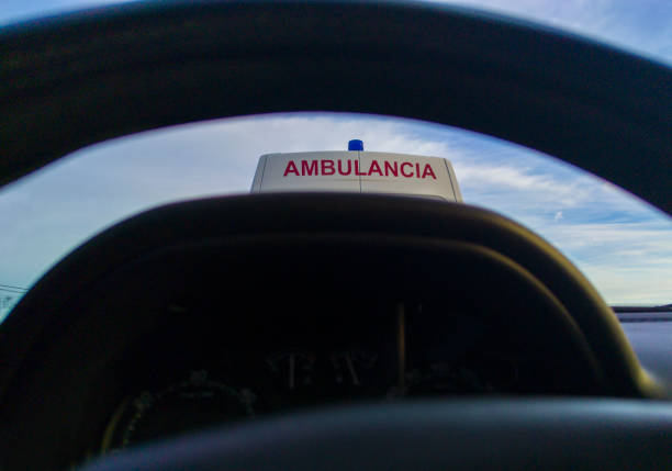 Driving behind an ambulance on local road. View from the inside of the car. View from the inside of the car