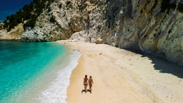 istock Two beautiful young women walking, relaxing and sunbathing on beach. Aerial view 2015652007