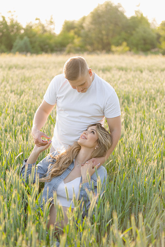 A couple enjoying a peaceful moment among the wheat plants in a beautiful, natural landscape, surrounded by the beauty of nature and agriculture