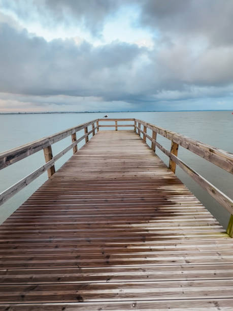 istock Empty wooden pier with dramatic sky and calm water 2015666312
